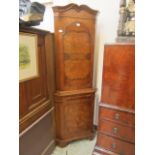 A reproduction burr walnut floor standing corner cupboard with brushing slide