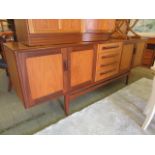 A mid-20th century teak sideboard having four center drawers flanked by cupboard doors