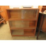 A mid-20th century teak cabinet having glazed sliding doors