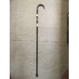 An ebonised walking stick with horn handle and silver hallmark collars