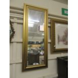 A modern gilt framed rectangular wall mirror