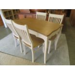 A reproduction lined oak white painted dining table with a set of four matching chairs