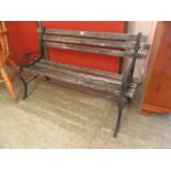 A weathered wooden garden bench with metal ends