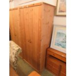 A modern pine two door wardrobe