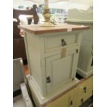 A green painted bedside cabinet having single drawer above cupboard door