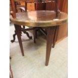 An eastern brass engraved circular topped table on wooden base