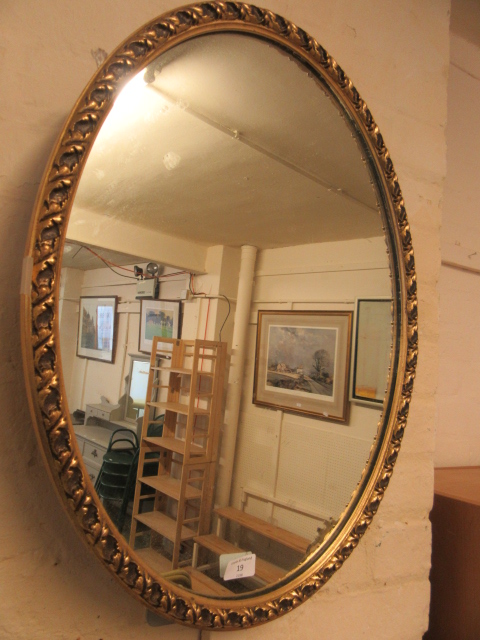 An oval gilt framed wall mirror