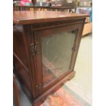 A reproduction oak cabinet having a leaded glazed door