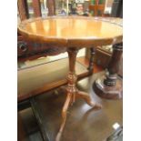 A reproduction walnut pedestal wine table