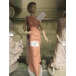 A Nao figurine of young lady with peach coloured dress