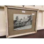 A framed and glazed early 20th century photograph a thatched cottage