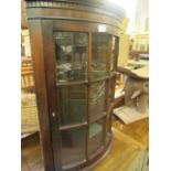 A reproduction bow fronted corner wall mounted cupboard