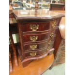 A reproduction mahogany serpentine fronted chest of four drawers of small proportions