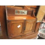 A walnut two door cabinet with small mirror