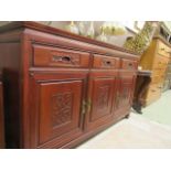 A Chinese hardwood dresser base having three drawers above three carved panel doors