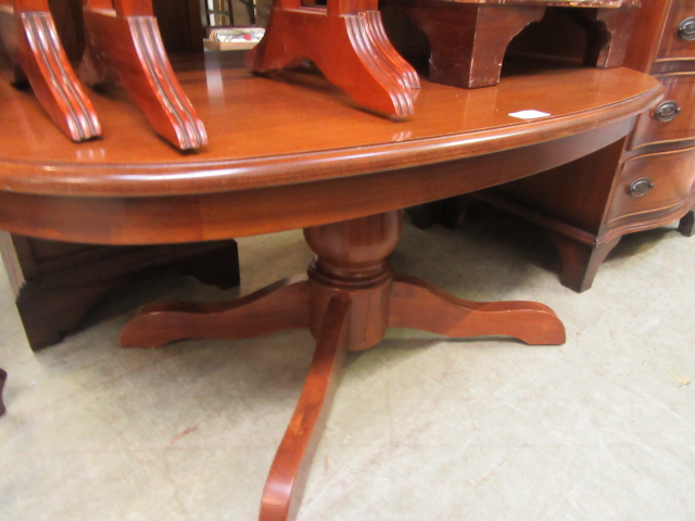 A reproduction wooden oval single pedestal occasional table