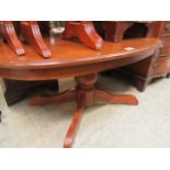 A reproduction wooden oval single pedestal occasional table