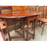 A mid-20th century oak gate leg table with barley twist supports