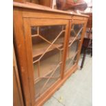 A waxed pine bookcase having a pair of glazed doors