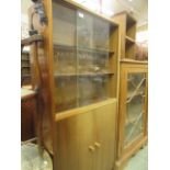 A mid-20th century cabinet having a pair of sliding glazed doors to top with a pair of solid doors