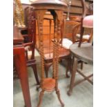 A reproduction mahogany effect jardiniere stand having a barley twist support with under tier