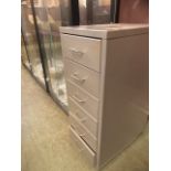 A grey metal six drawer cabinet