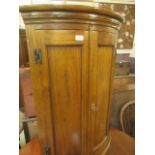 A reproduction Georgian style bow fronted wall mounted corner cupboard