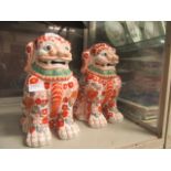 A pair of large red decorated foo dogs