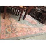 A Chinese style green and pink patterned rectangular rug