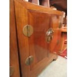 An eastern hardwood two door cabinet with brass furniture