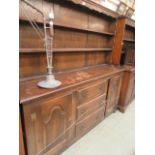 A mid-20th century oak dresser having plate rack to top,
