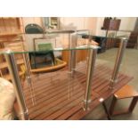 A pair of modern glass and brushed chrome legged occasional tables