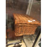 A wicker basket containing figurines, boxes, Oxo tin,