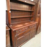 A mid-20th century oak dresser hving plate rack to top,