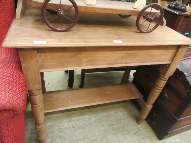 A scrubbed pine washstand with a green tiled back