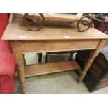 A scrubbed pine washstand with a green tiled back