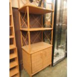 A wicker and bamboo shelving unit with two cupboard doors to base