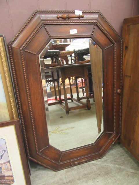 An oak framed mid-20th century bevel glass wall mirror