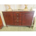 A modern mahogany and brass inlaid sideboard with four central drawers flanked by cupboard doors