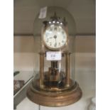 An early 20th century brass anniversary clock under glass dome