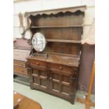 A mid-20th century oak dresser having plate rack to top over two drawers above cupboard doors to