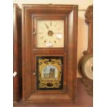 An early 20th century walnut cased American drop-dial wall clock with glass panel depicting