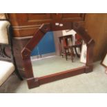 A stained wooden framed wall mirror