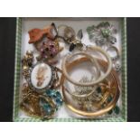 A tray containing an assortment of costume jewellery to include brooches, bracelets, rings,