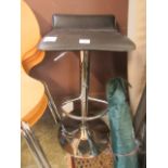 A chrome supported stool with black rexine seat