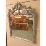 A silver painted ornate framed over mantle mirror