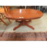 A reproduction wooden oval single pedestal occasional table