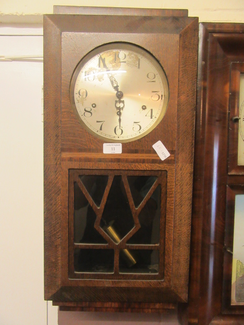 An early 20th century oak cased drop-dial wall clock