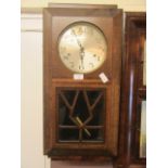 An early 20th century oak cased drop-dial wall clock