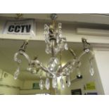 An early 20th century six branch brass and cut glass ceiling hanging chandelier